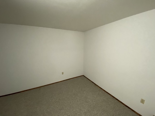 The corner of a room with bare walls.