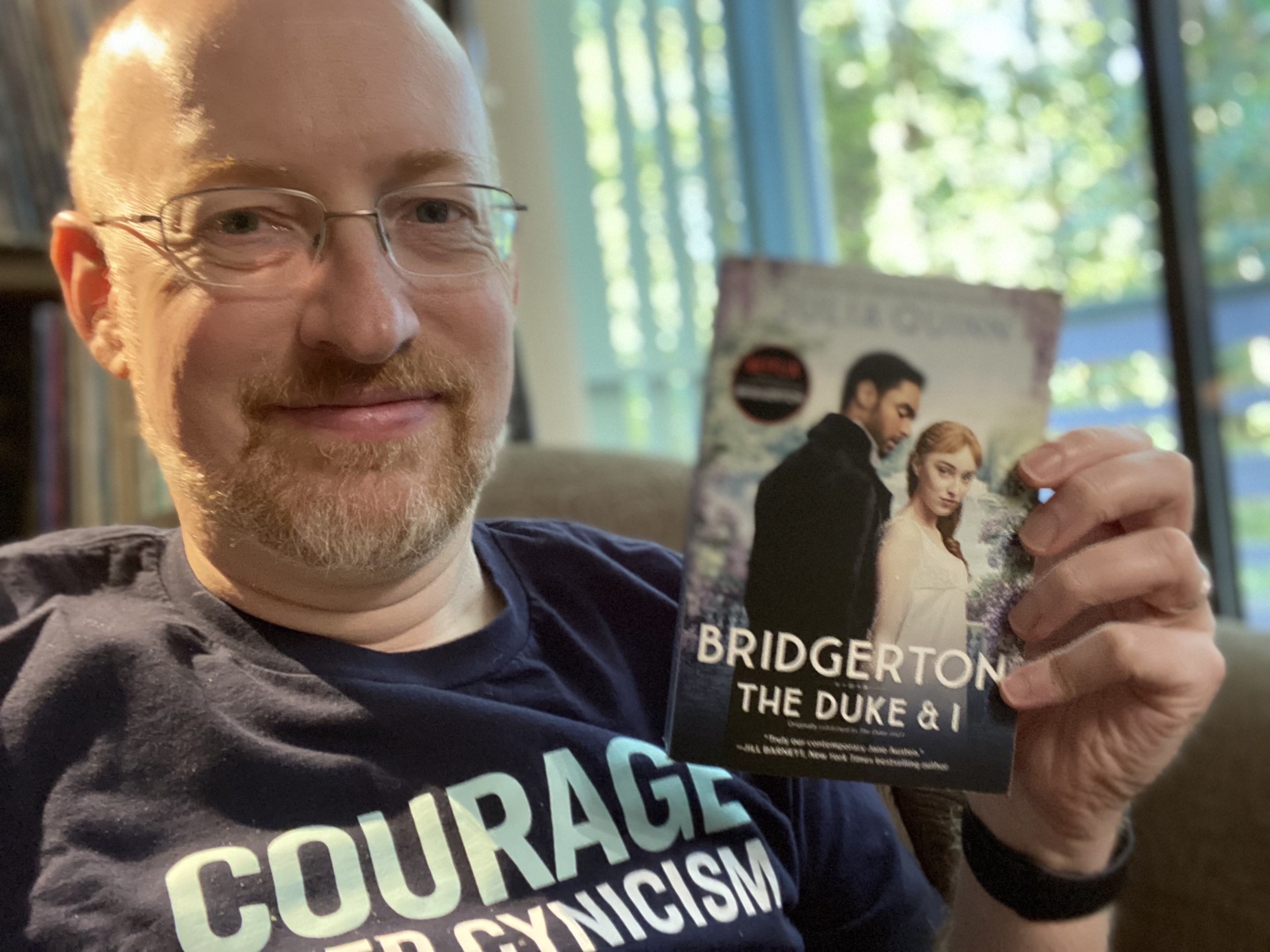 Photo of Michael Hanscom holding the book _The Duke and I_ by Julia Quinn