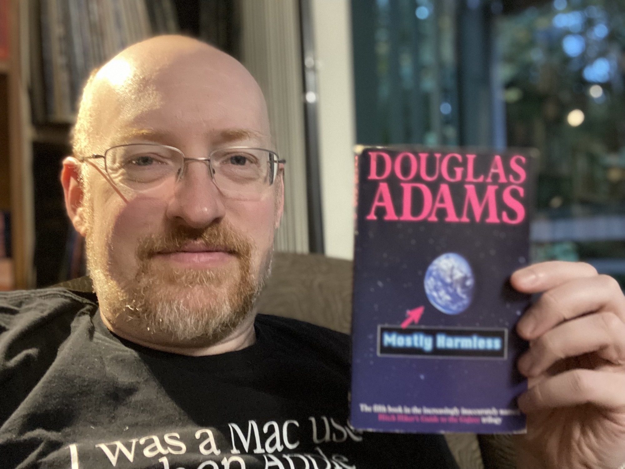 Photo of Michael Hanscom holding the book _Mostly Harmless_ by Douglas Adams