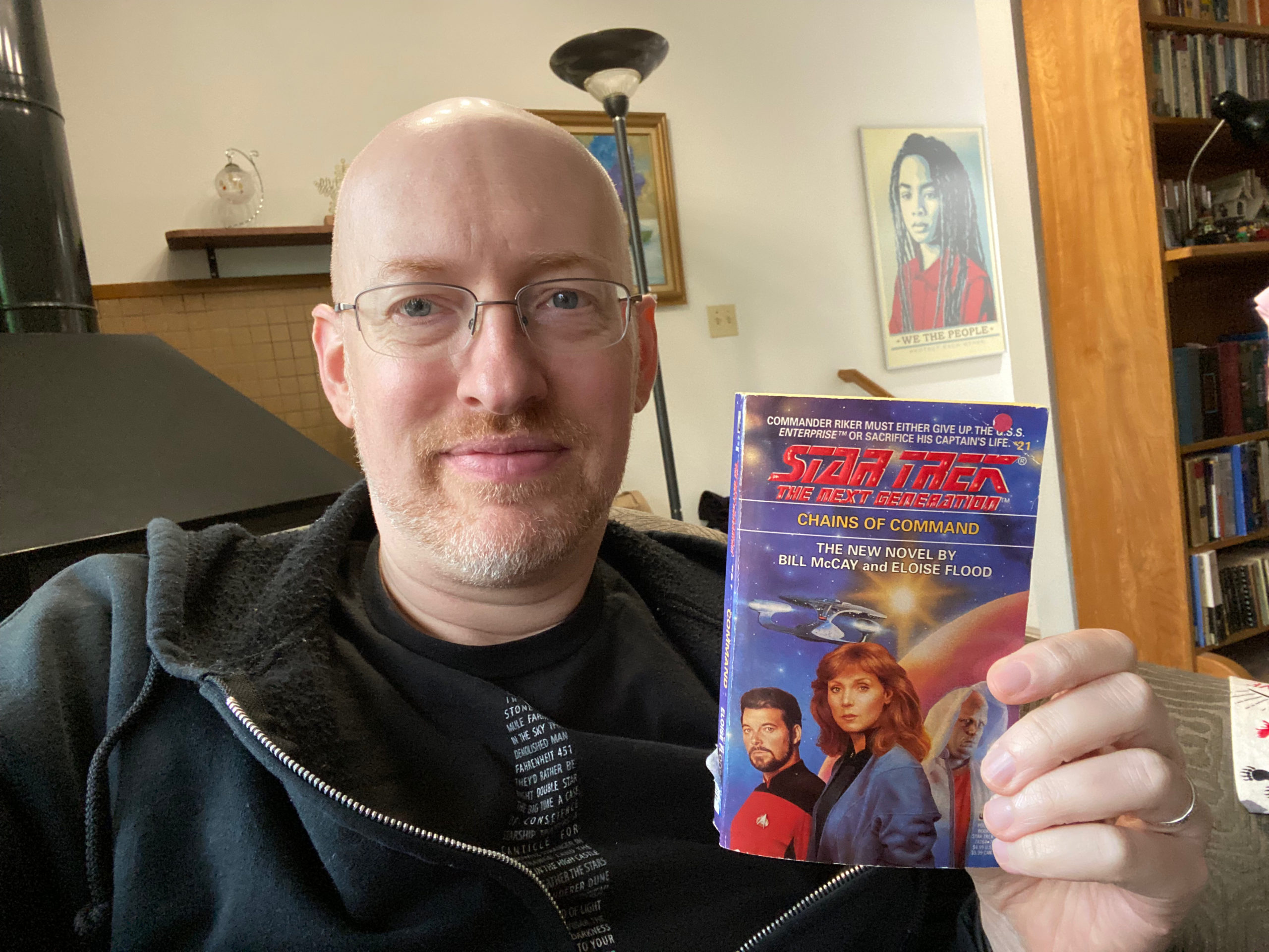 Photo of Michael Hanscom holding the book _Chains of Command_ by Bill McCay and Eloise Flood