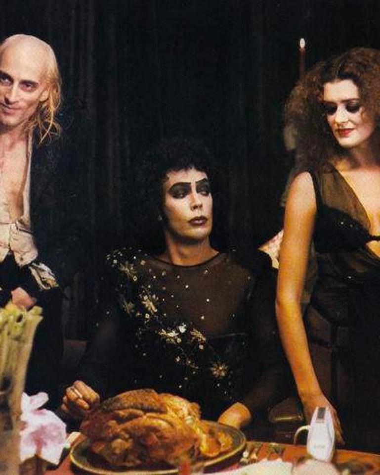 Riff-Raff, Frank N. Furter, and Magenta around the dinner table in the Rocky Horror Picture Show.