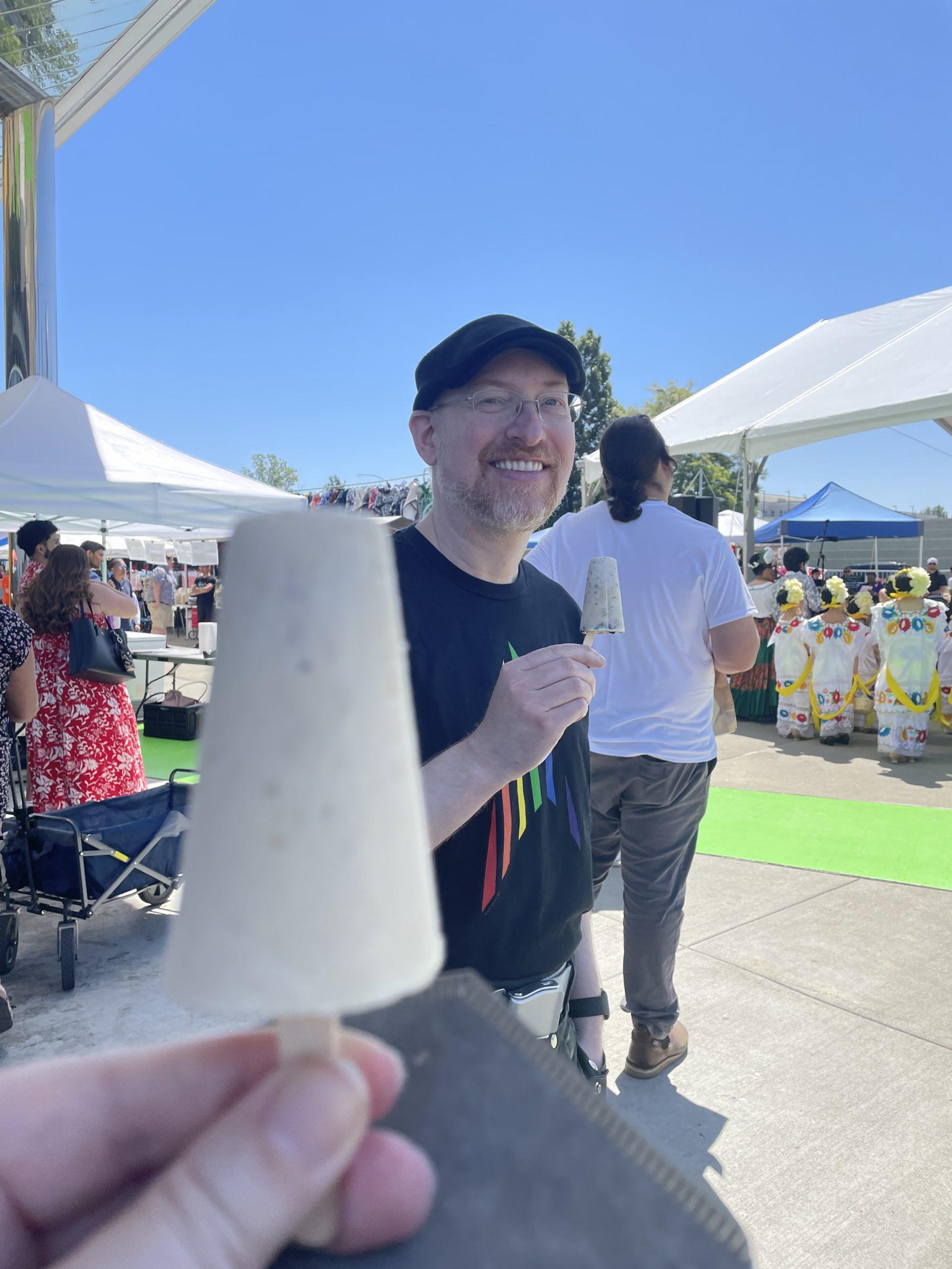 Me smiling and holding an ice cream, my wife's ice cream is slighlty out of focus in the foreground.