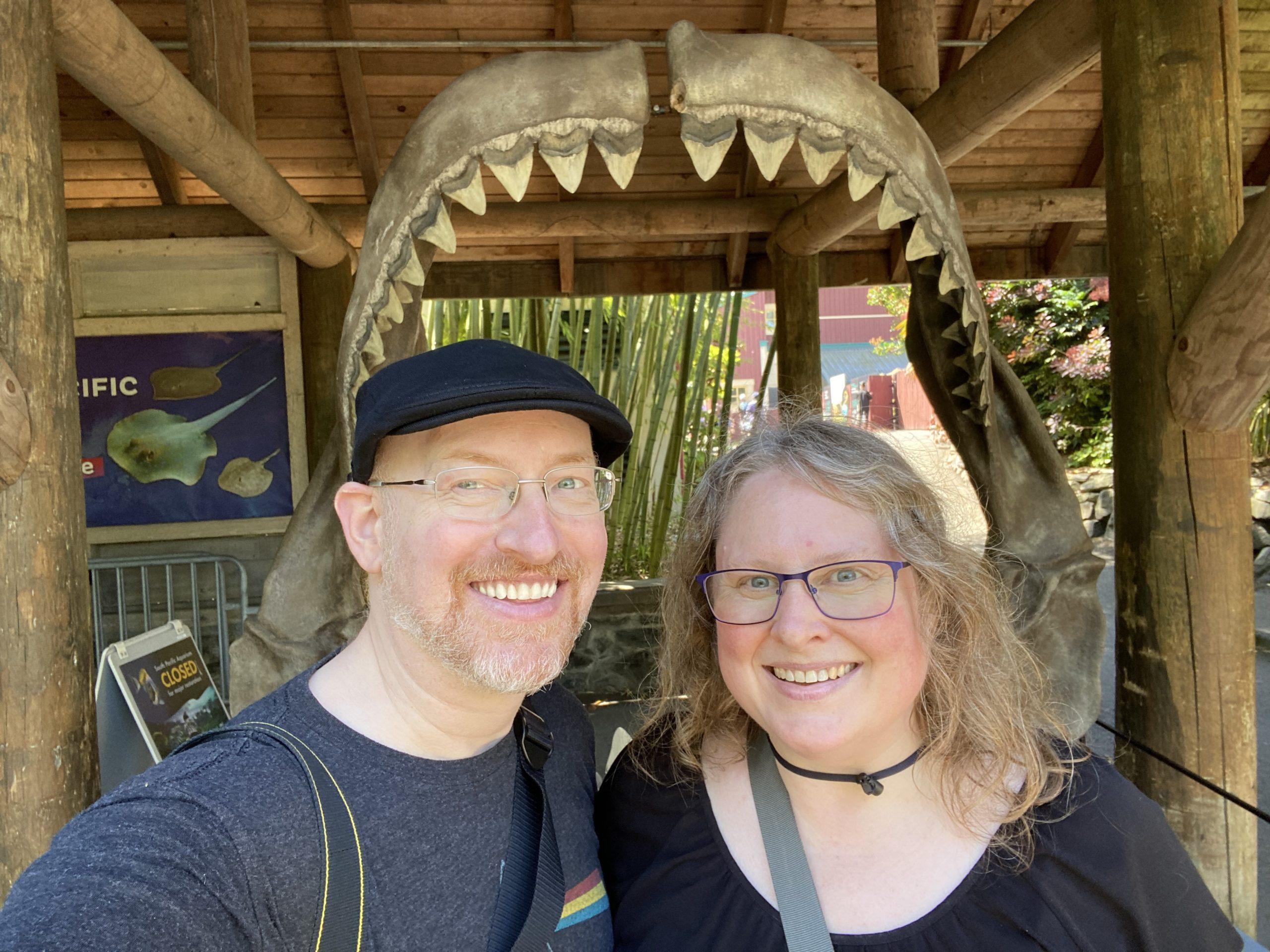 Me and my wife standing in front of a large shark's jaw.