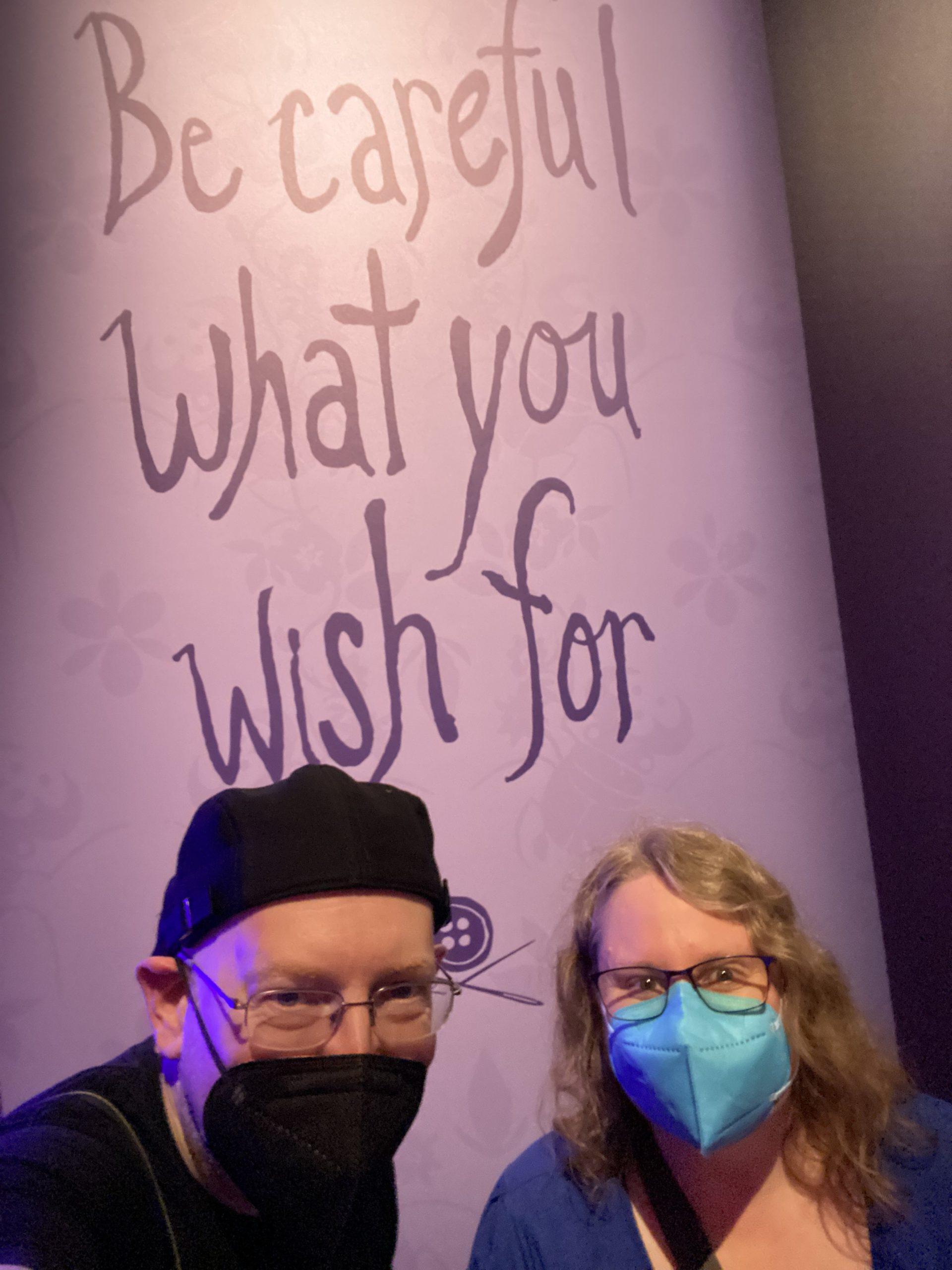 My wife and I in front of a sign saying "be careful what you wish for".