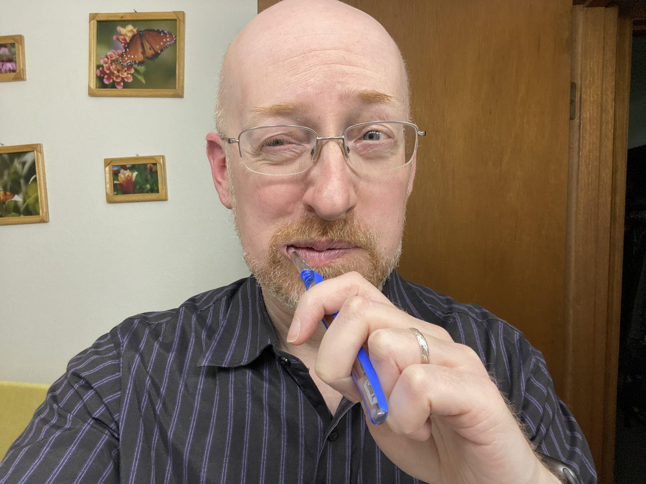 Me in our bathroom with a toothbrush in my mouth and a disgusted expression on my face.