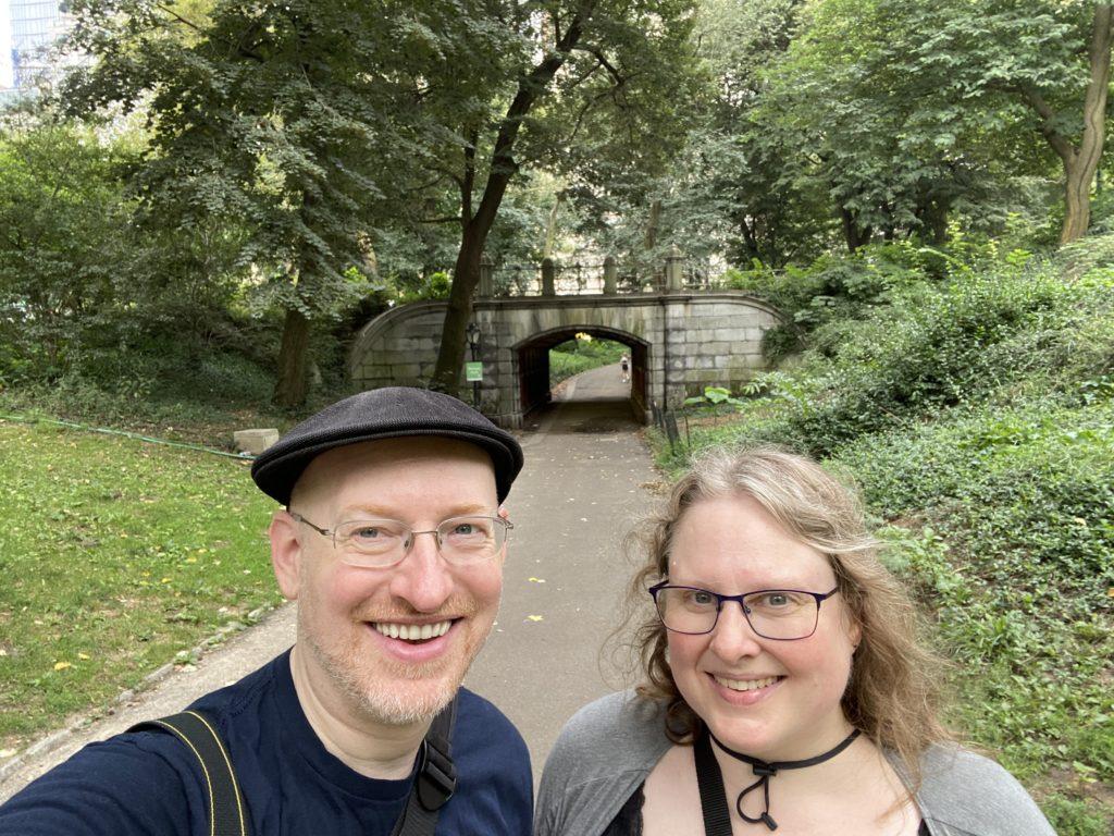 My wife and me standing in front of one of the stone archway bridges in Central Park.