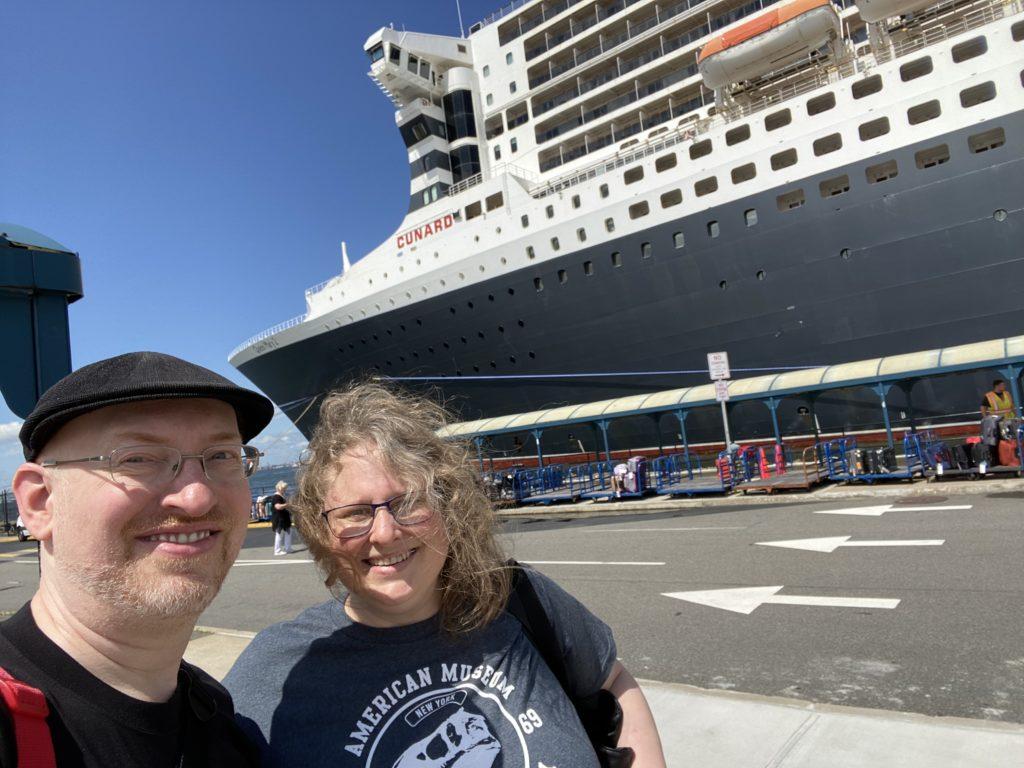 My wife and I outside on Brooklyn’s Pier 12 cruise ship terminal. Behind us is the Queen Mary 2 ocean liner.