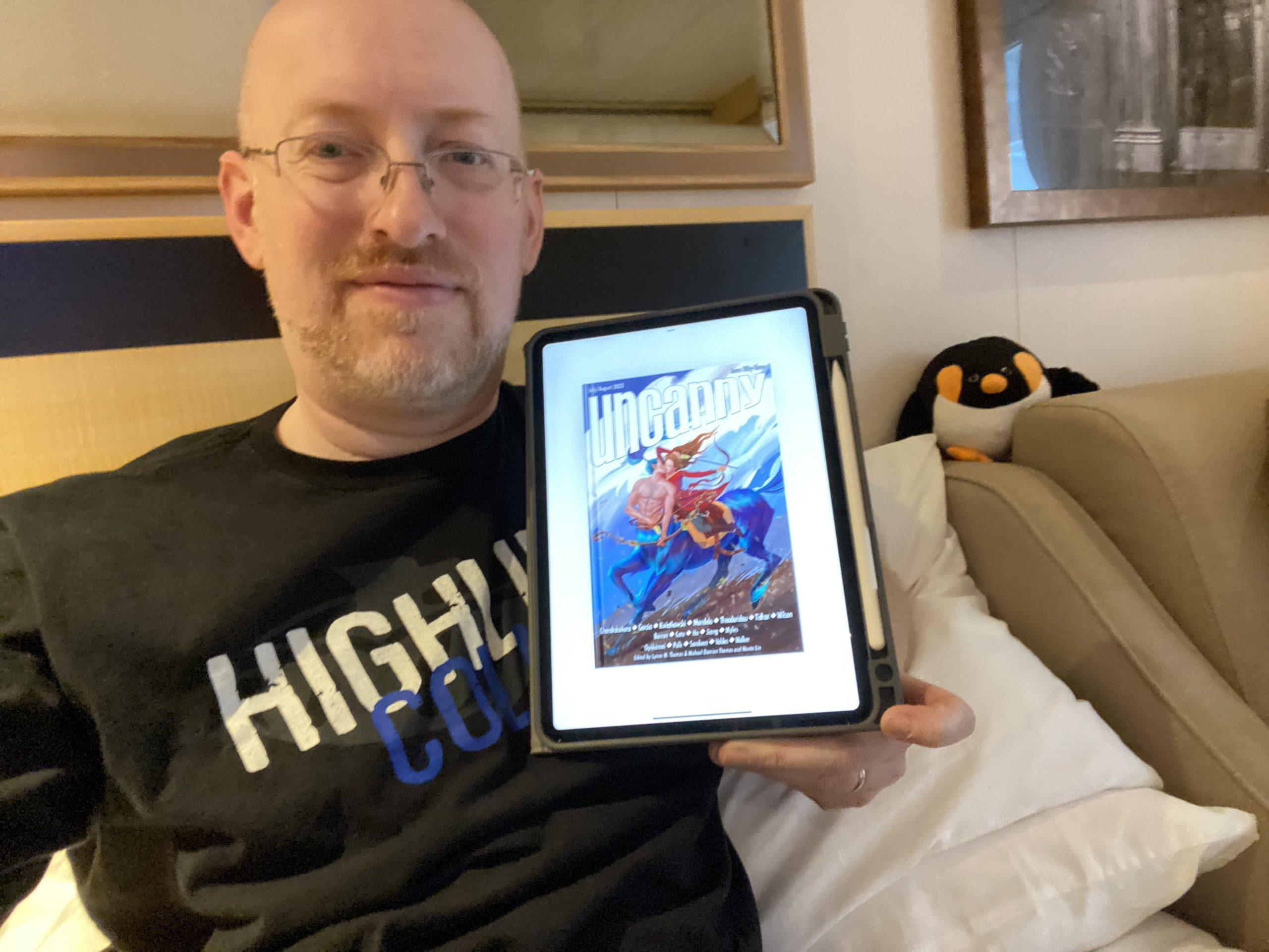Me holding my iPad with the Uncanny Issue 53 cover shown on the screen