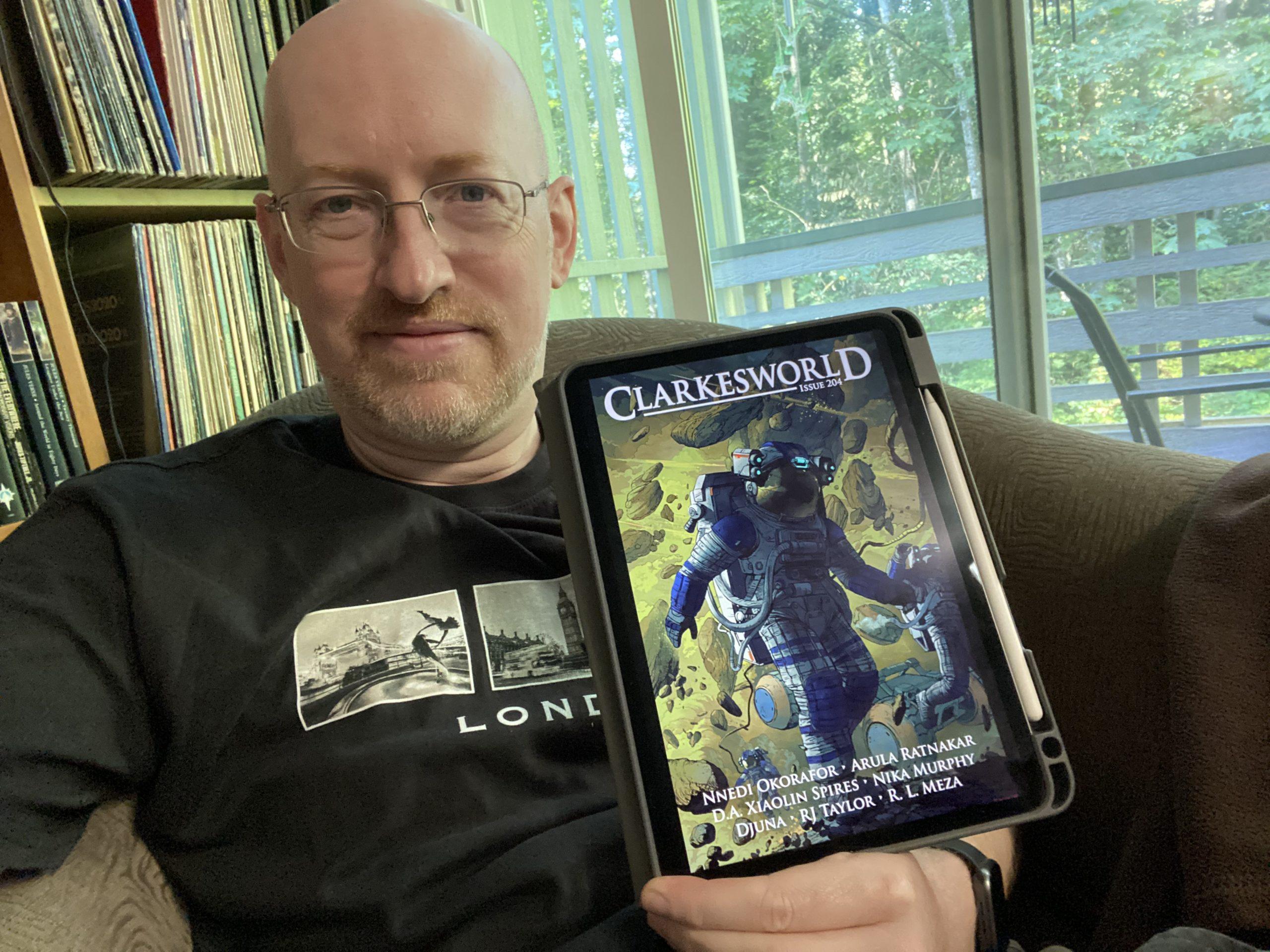 Me holding my iPad showing the cover of Clarkesworld 204