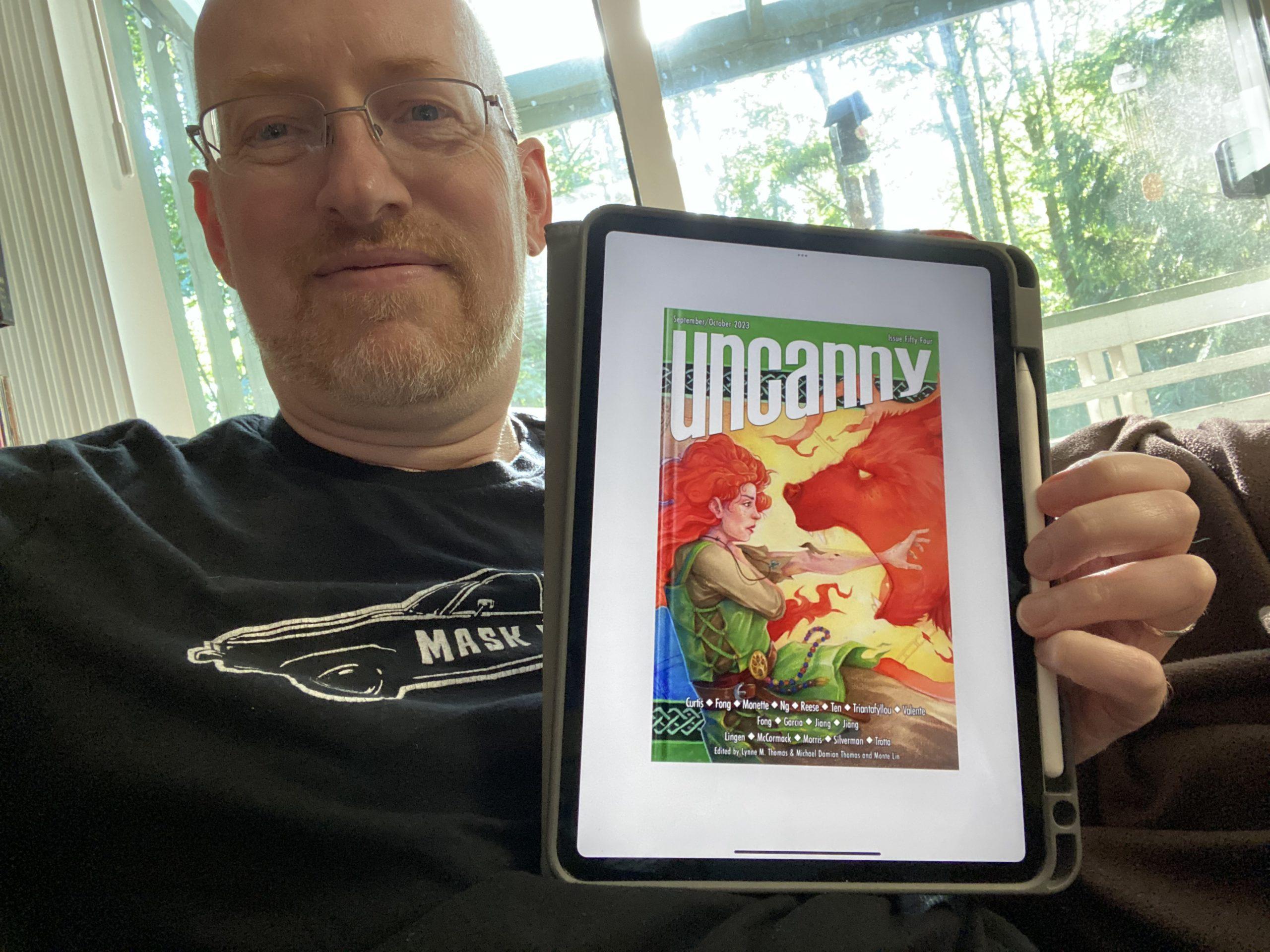 Me holding my iPad displaying the cover for Uncanny issue 54.