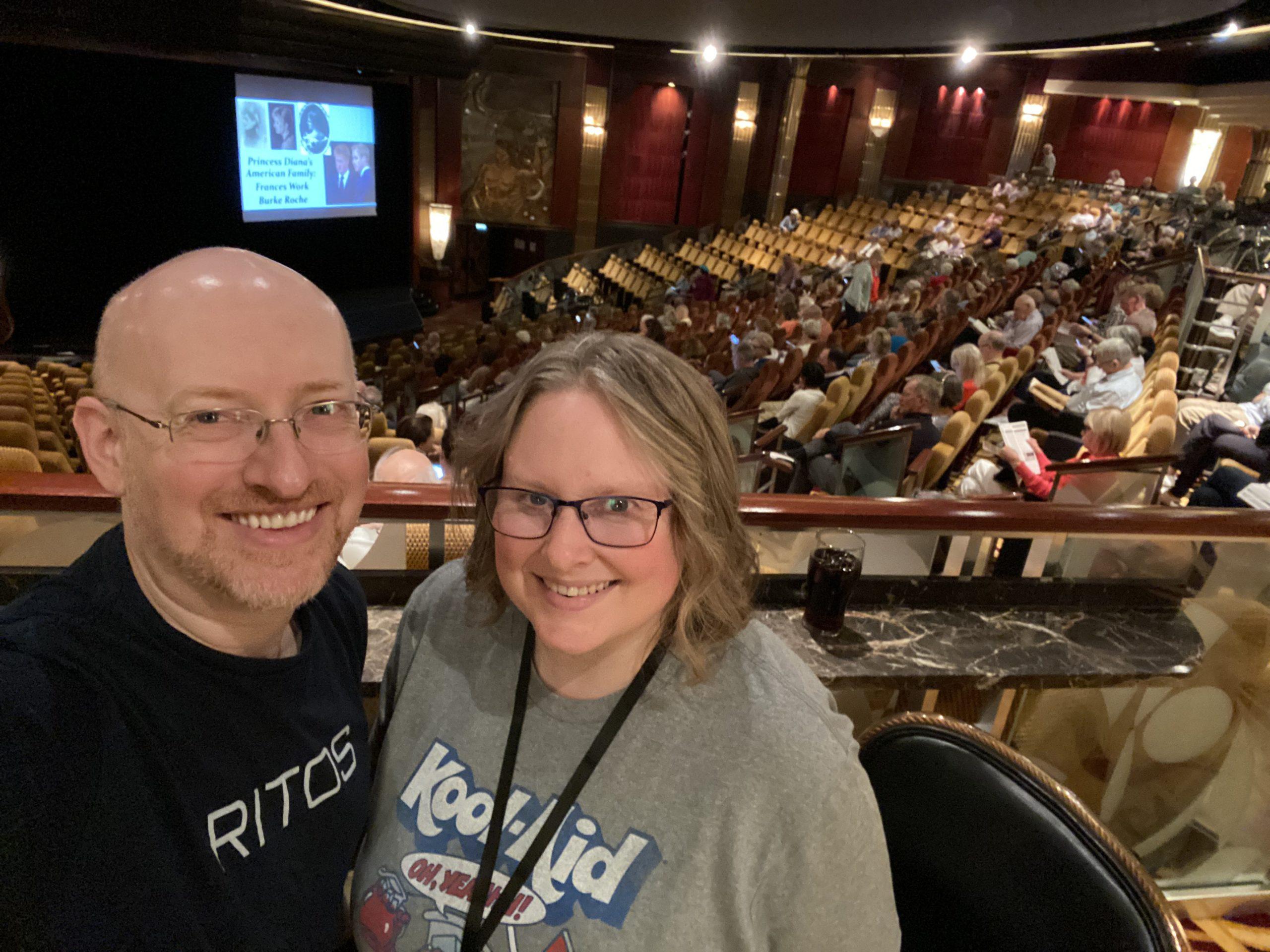 My wife and I standing towards the back of the lecture hall as people fill the seats.