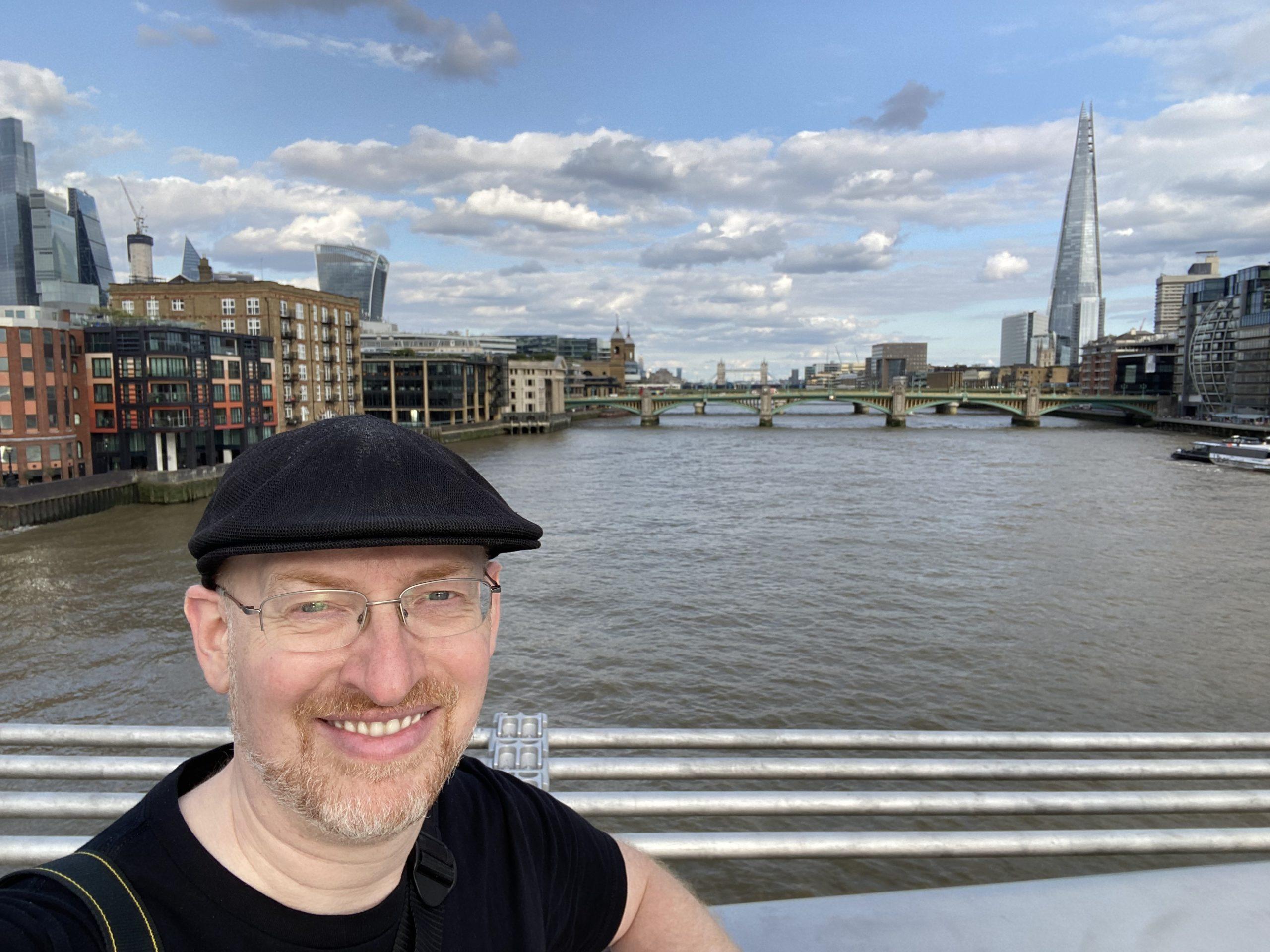 Me midway across the Millennium Bridge, with the Shard and Tower Bridge visible in the distance.