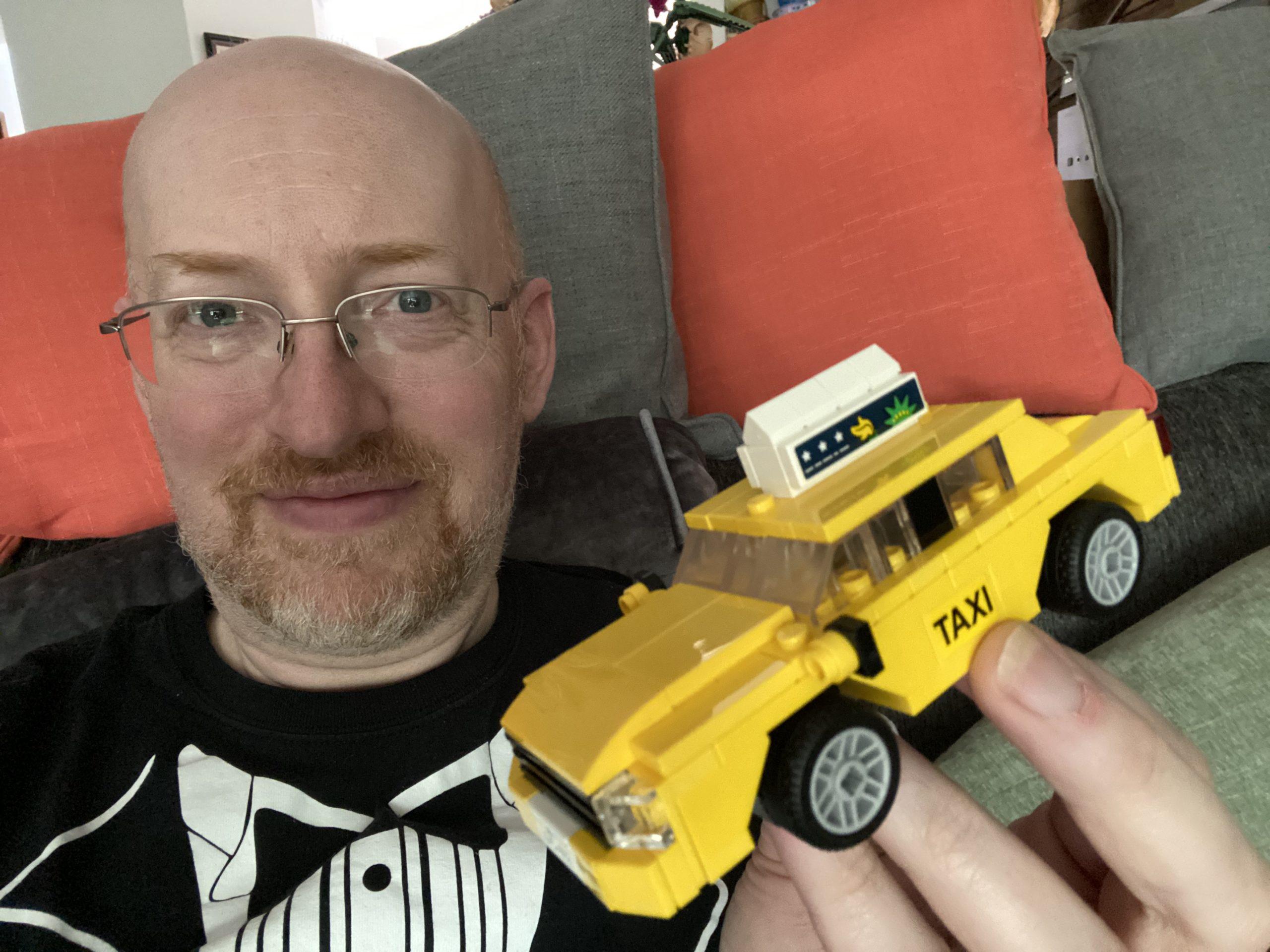 Me holding a Lego yellow taxi cab.