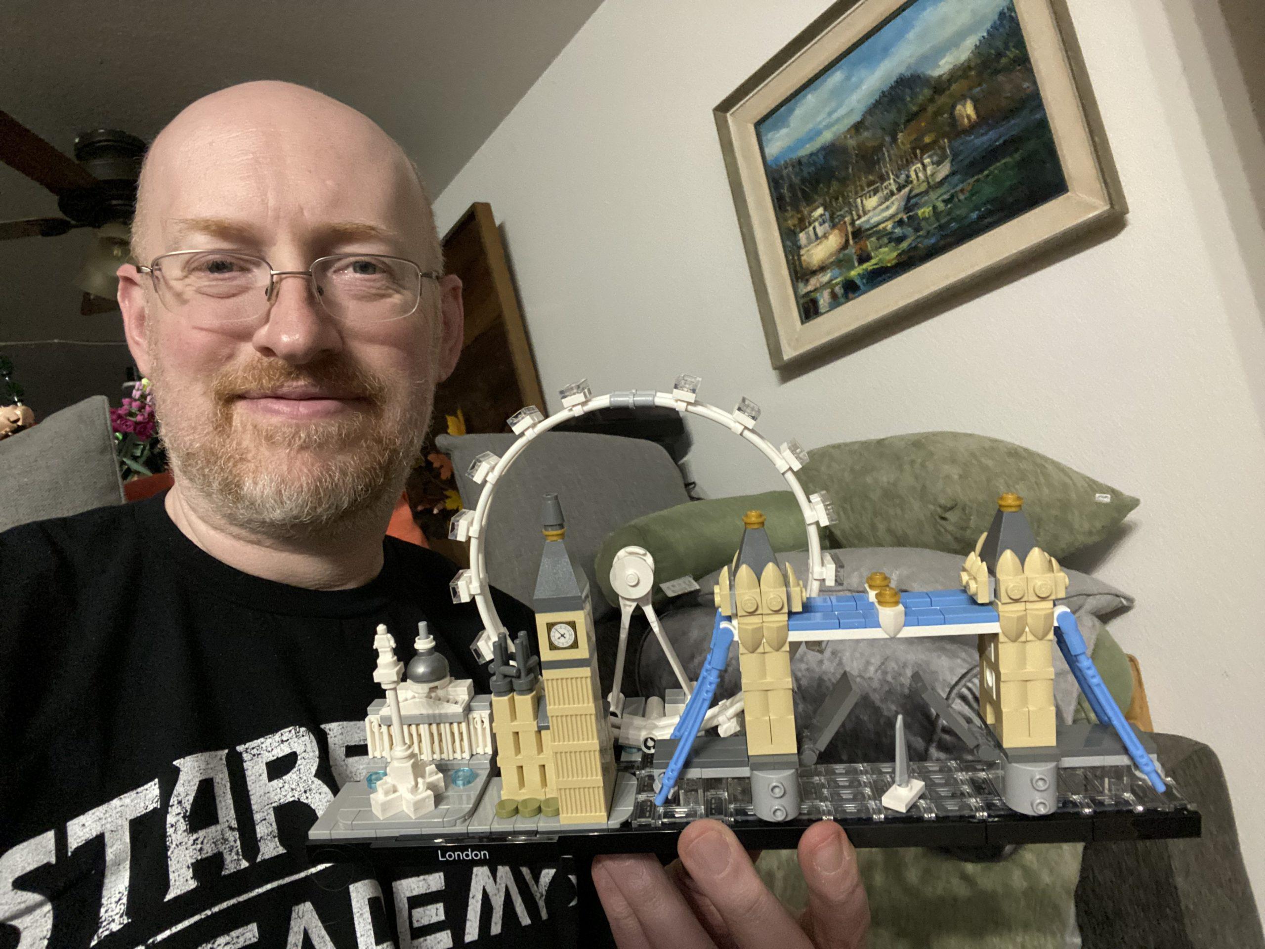 Me holding a Lego version of London showing the National Gallery, Nelson's Column, Parliament and Big Ben, the London Eye, and Tower Bridge.