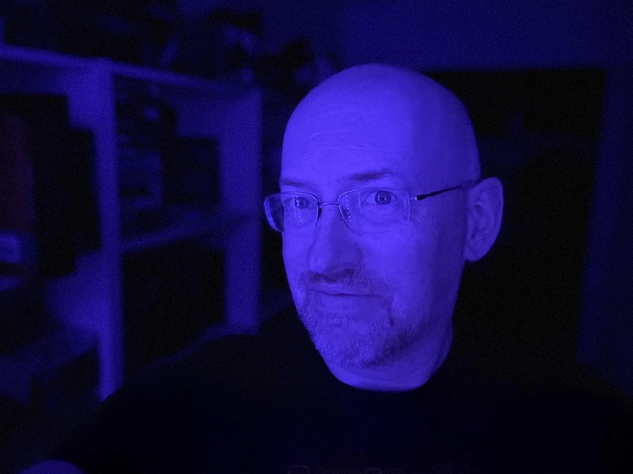 Me, with a slight smile, lit entirely in purple.