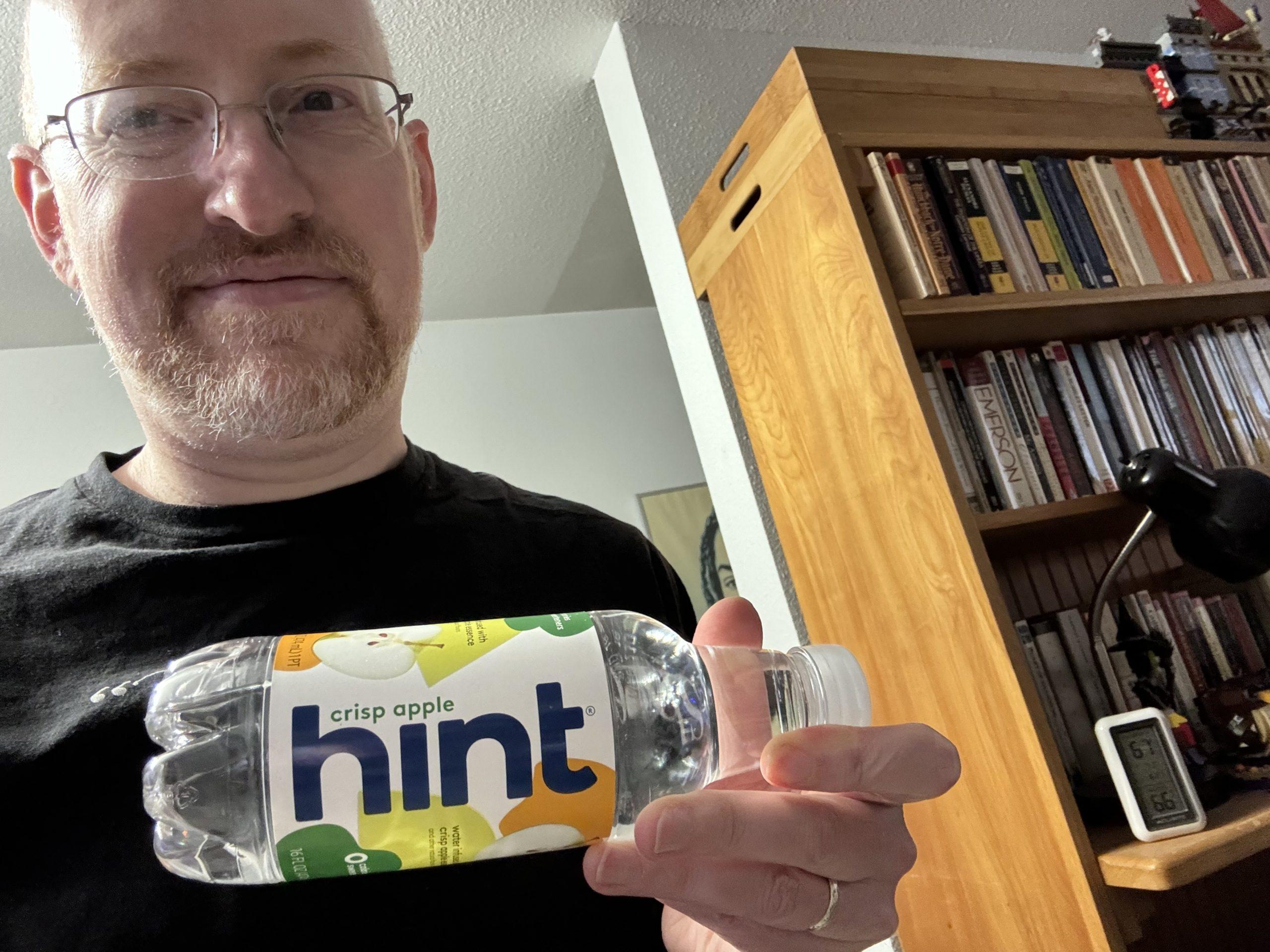 Me in my living room, holding a bottle of 'Hint' water.