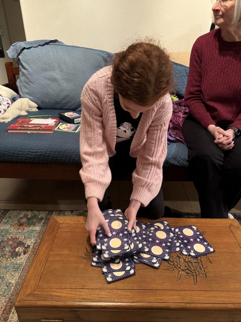 My niece shuffling a deck of tarot cards.