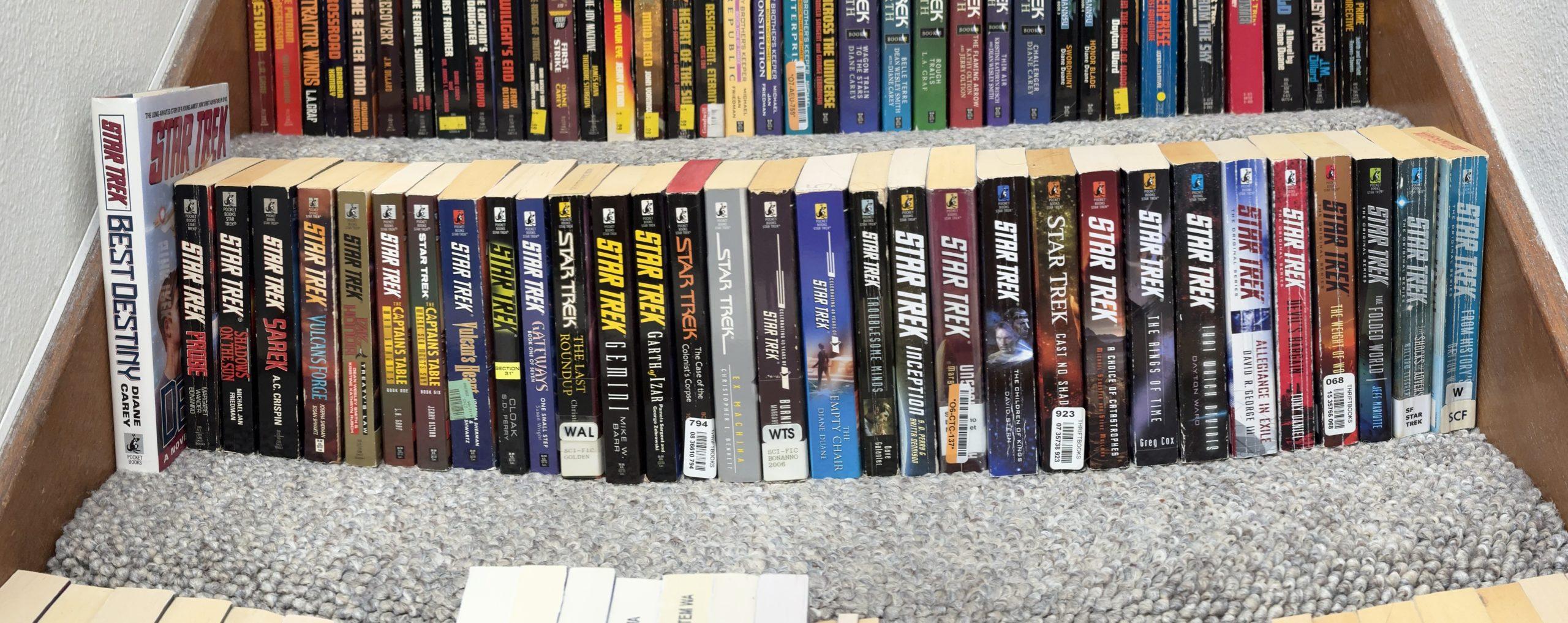 Panoramic shot of about 40 Star Trek novels across a staircase step.