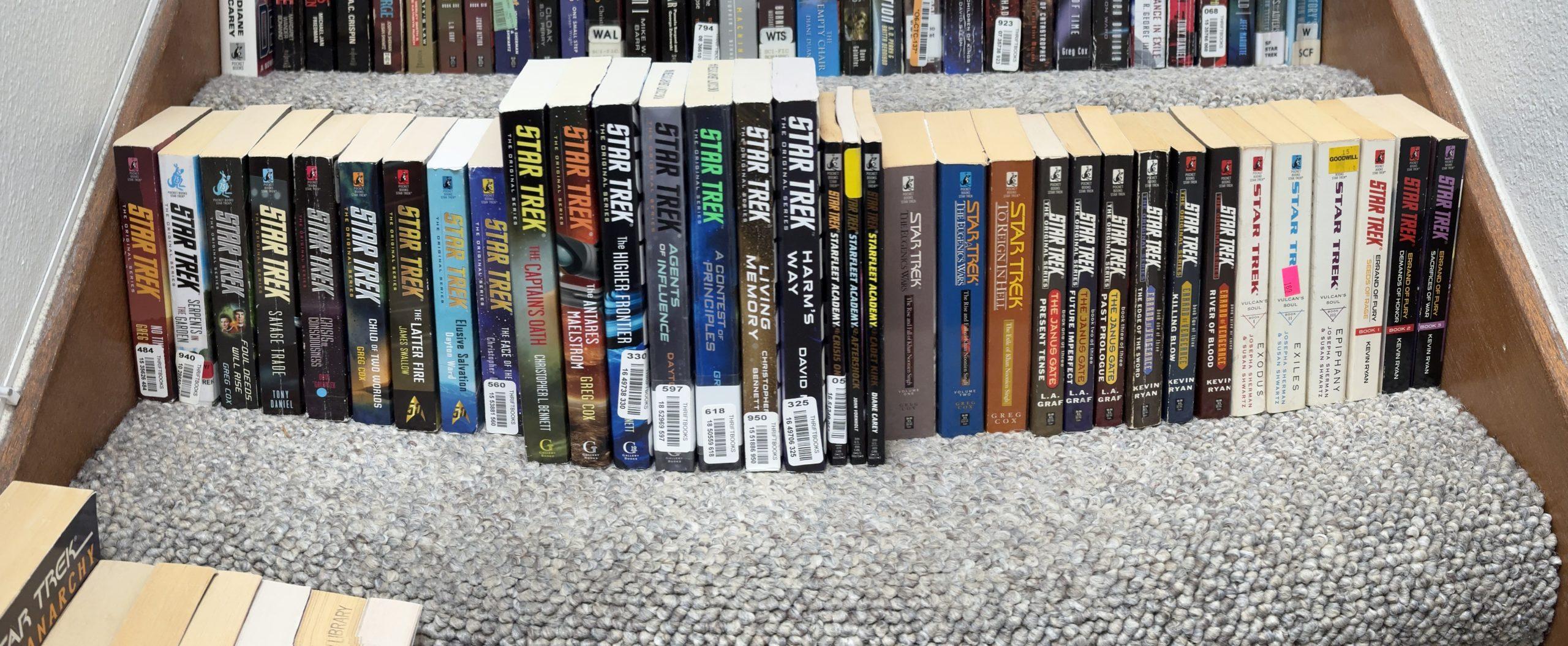 Panoramic shot of about 30 Star Trek novels across a staircase step.