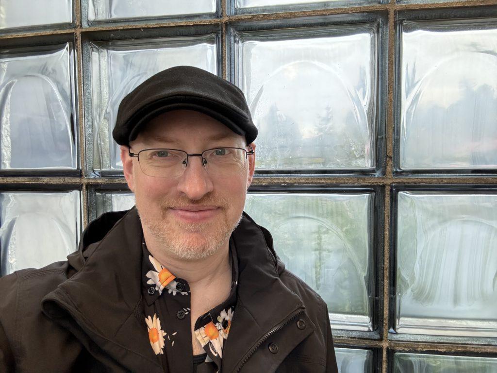 Me in front of a wall of large glass bricks.