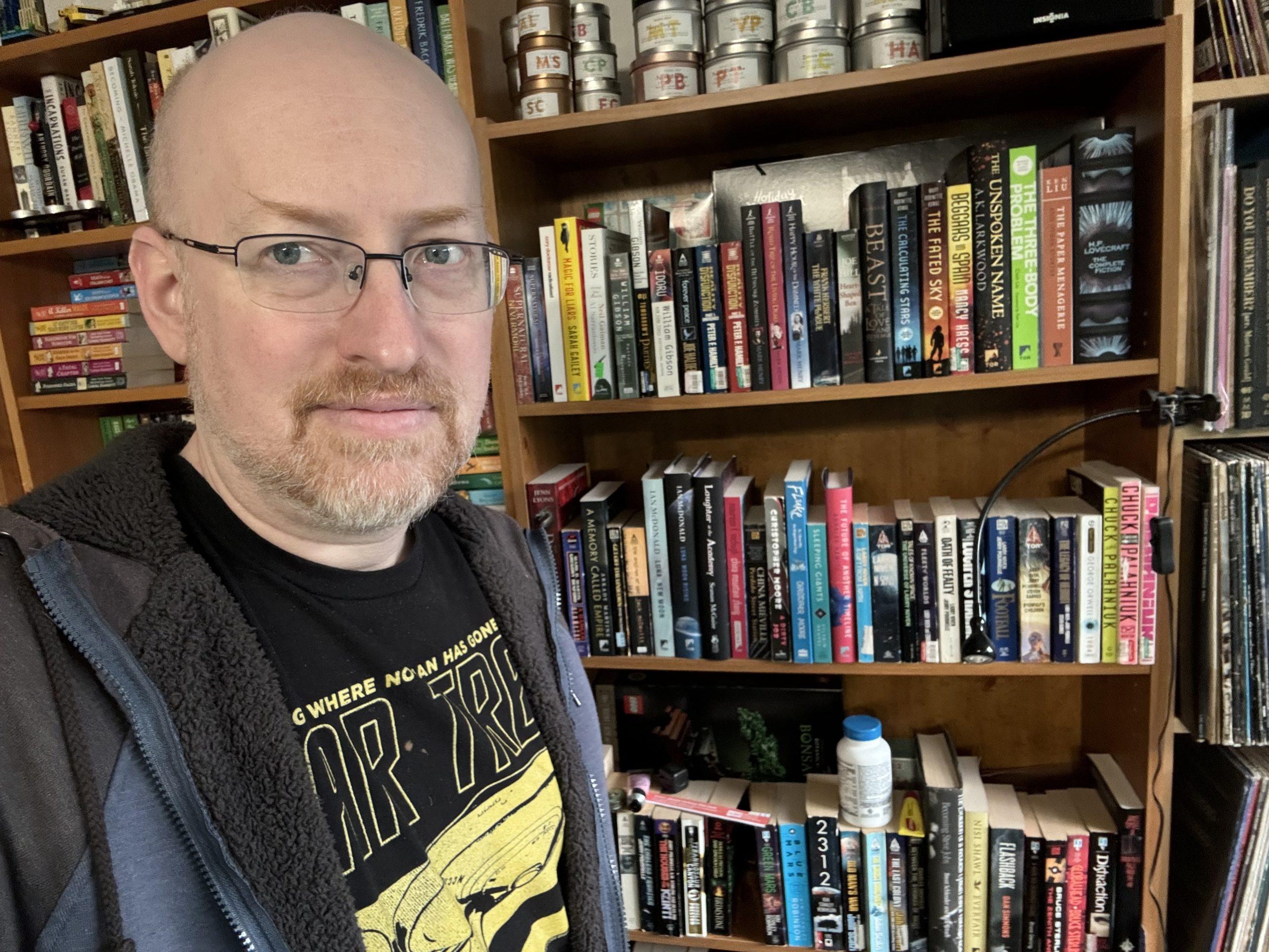 Me standing in front of a bookcase full of science fiction books.