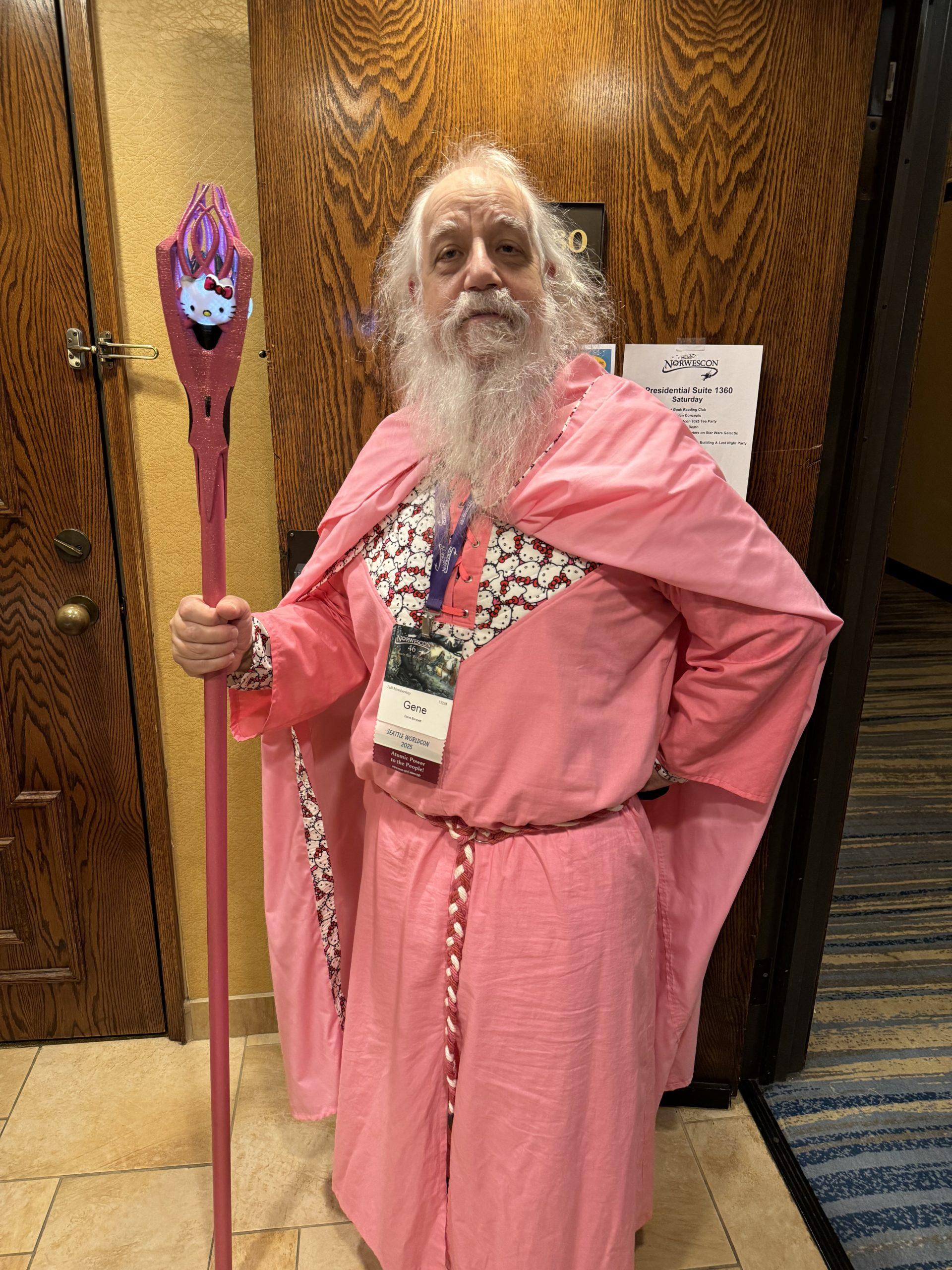 An old white man with white hair and long beard, wearing a pink robe and cloak with Hello Kitty accents, holding a pink staff with a Hello Kitty head attached.