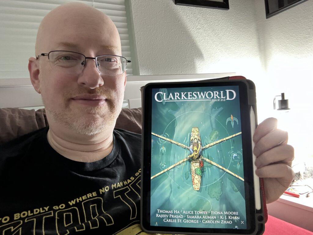Me holding my iPad displaying Clarkesworld 212.