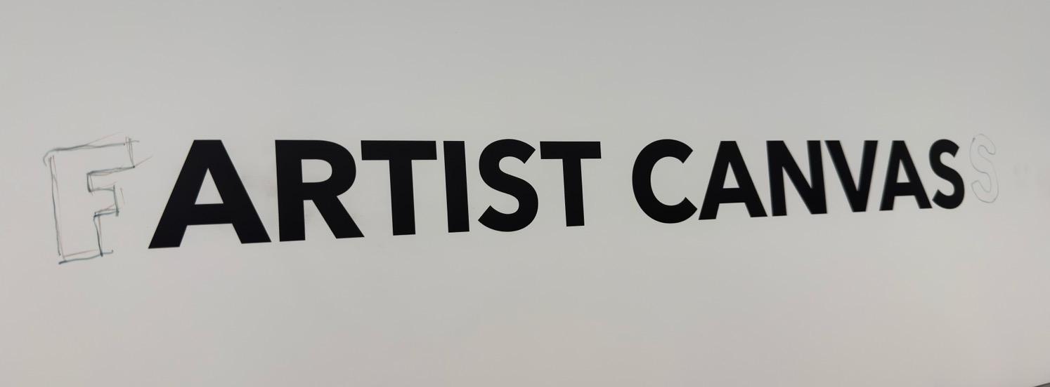 A store category sign for Artist Canvas that has been vandalized to read Fartist Canvass.