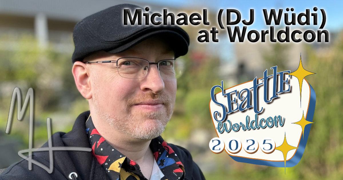Me, a white man with short-cropped greying red beard and glasses, with the Seattle Worldcon logo.