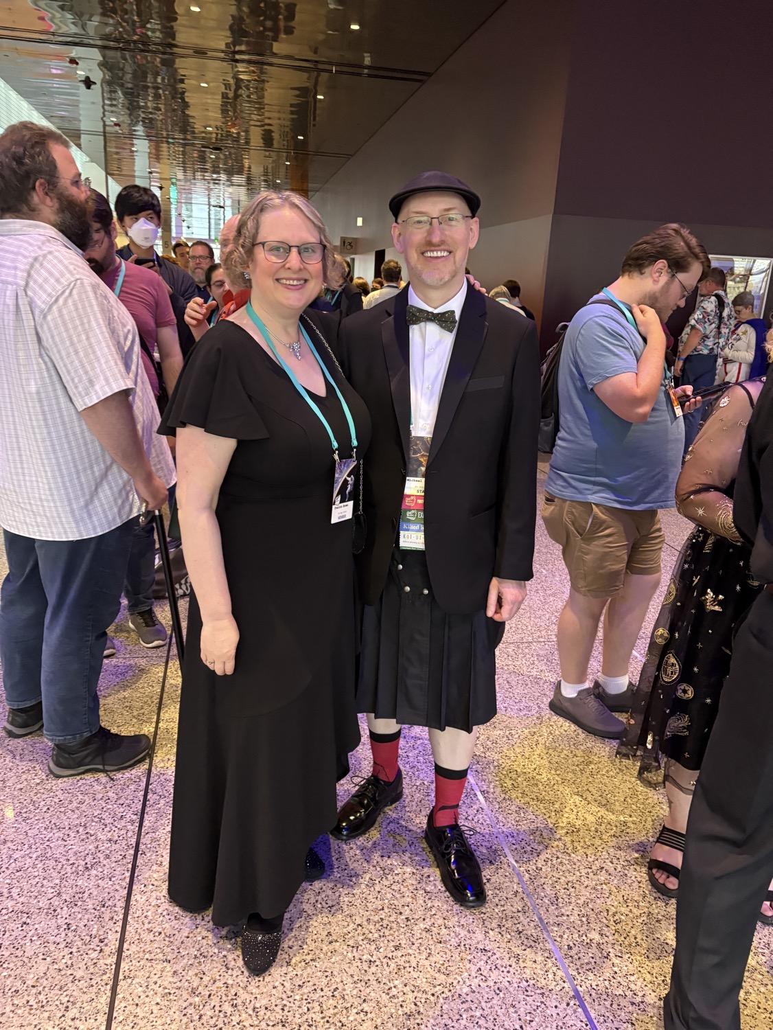 IMG_0981.jpeg My wife and I in line; she's in a nice long black dress with frilly hem, I'm in a black formal kilt, white shirt, black tux jacket, and bow tie.