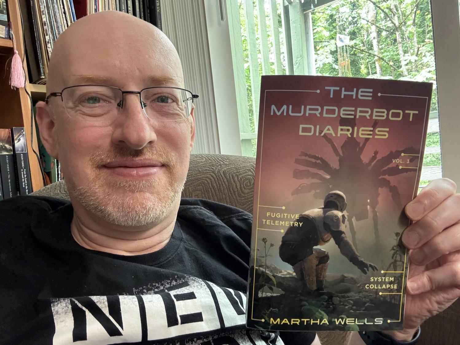 Me holding The Murderbot Diaries Vol. 3