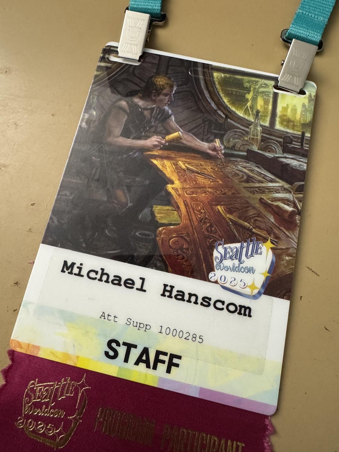 IMG_4737.jpeg My staff badge, with art by Donato Giancola of a craftsman carving a fancy wooden panel.