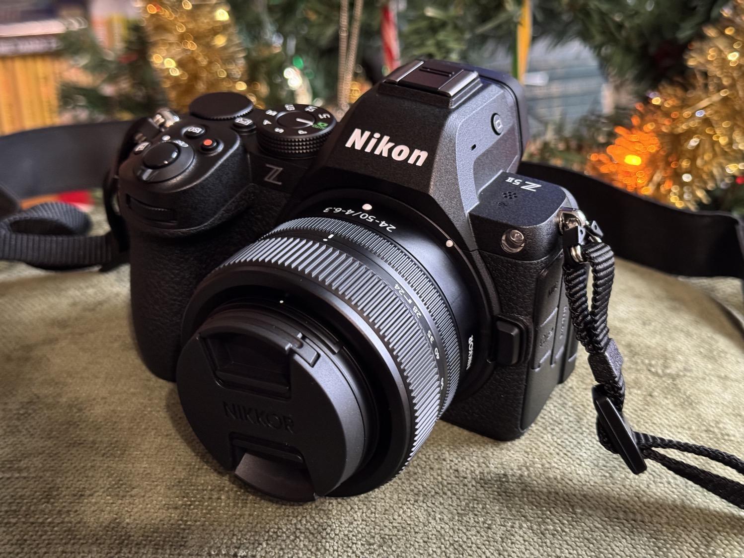 A Nikon Z5II camera sitting on a green cushion with a Christmas tree just visible in the background.