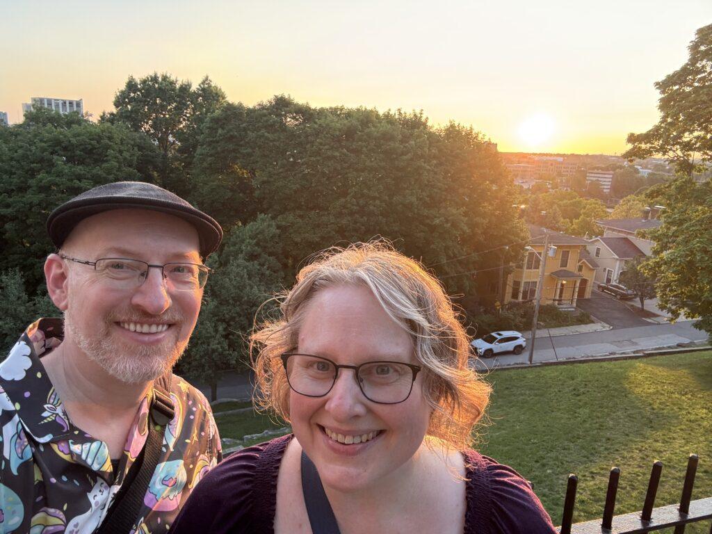Selfie of my wife and I on a hill overlooking Providence as the sun sets in the distance.