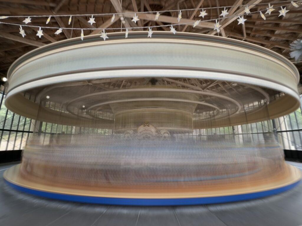 A carousel entirely motion blurred as if it was spinning at severely unsafe speeds.