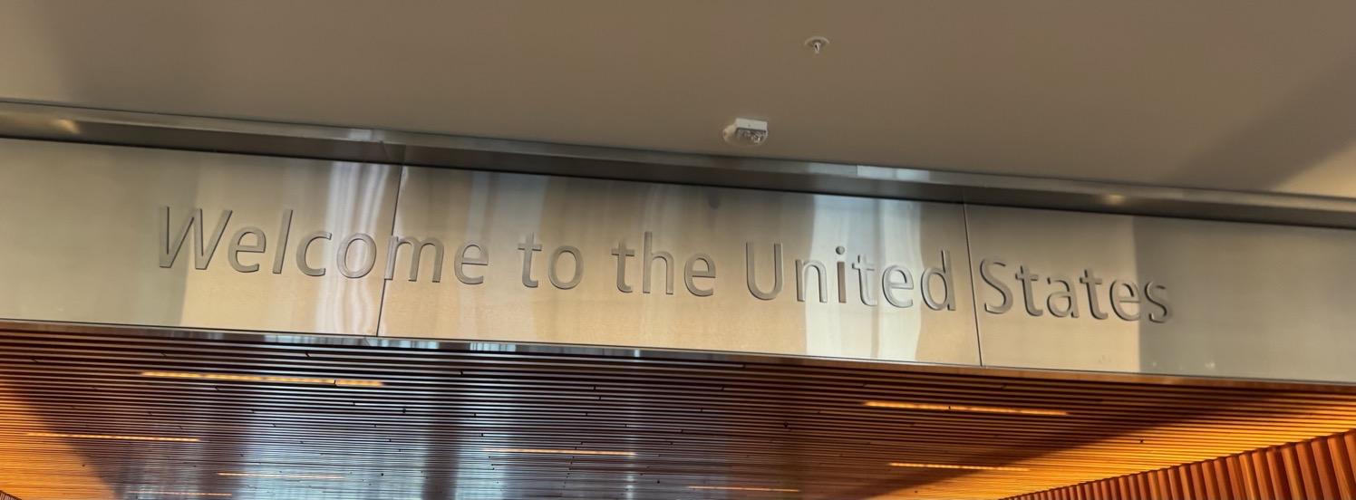 Metal text on a metal dropped ceiling that says 'Welcome to the United States'.