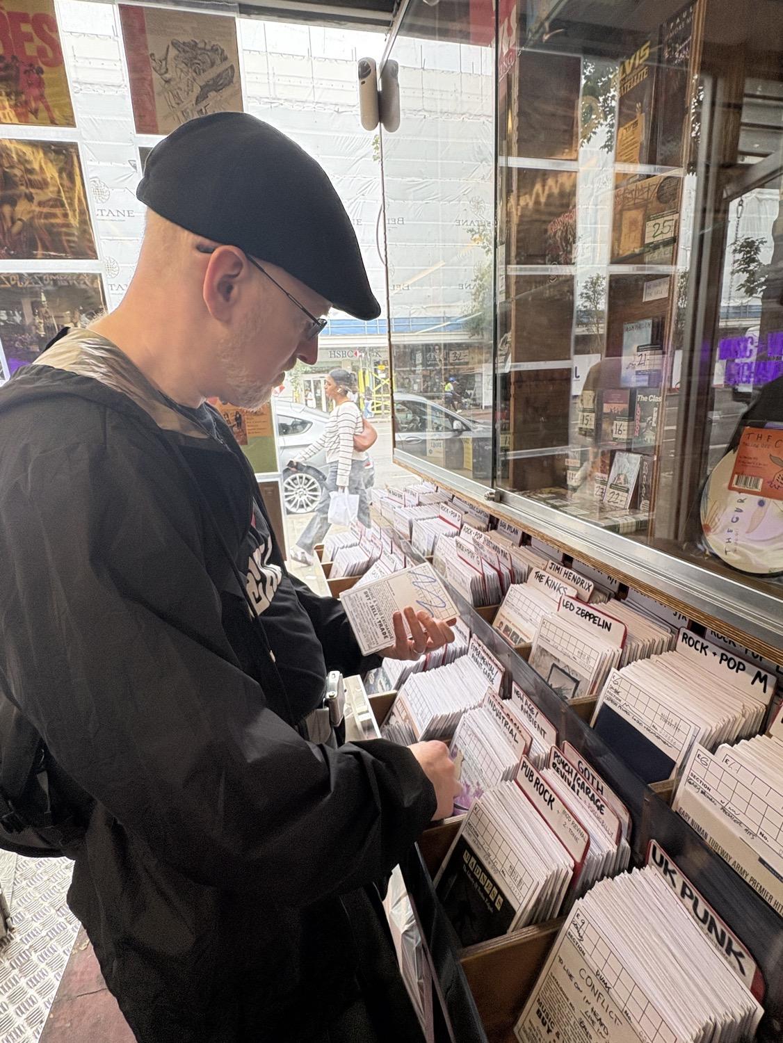 Me browsing through bins of plastic sleeves with CD booklets in them, organized and categorized with thicker plastic dividers.